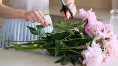 Woman arranging pink peony bouquet
