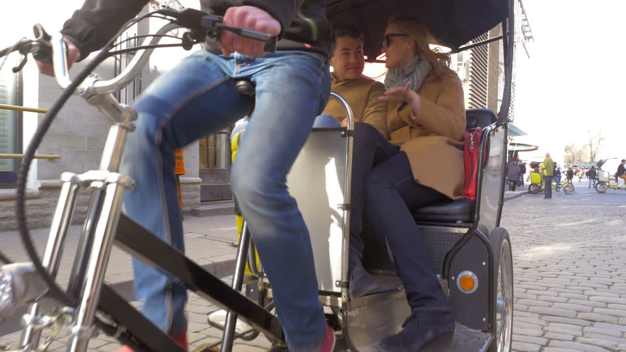 Couple riding in bicycle taxi and talking to each other