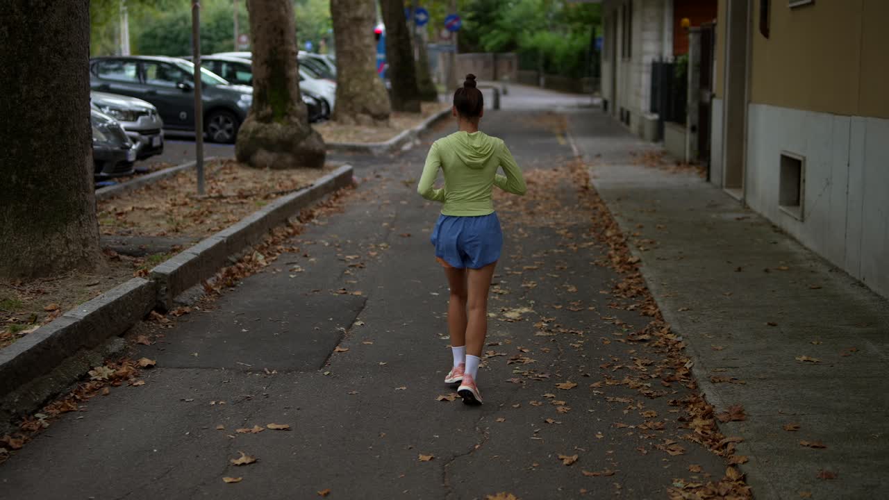 Woman Walking Down City Street in Autumn