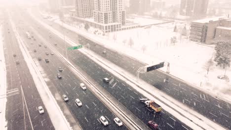 aerial, traffic driving on highway during a blizzard snow storm in canada