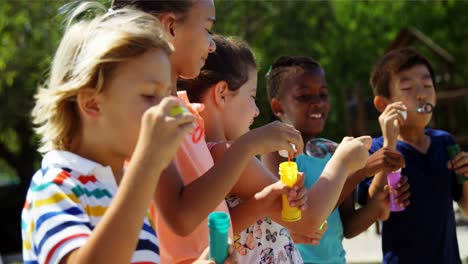 Schulkinder-Spielen-Mit-Seifenblasenstab-Auf-Dem-Spielplatz