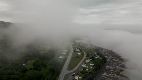 Flying-though-Fog-Above-Small-Costal-Village-on-Dark-Cold-Overcast-Winter-Morning,-Drone-Aerial,-Gaspesian