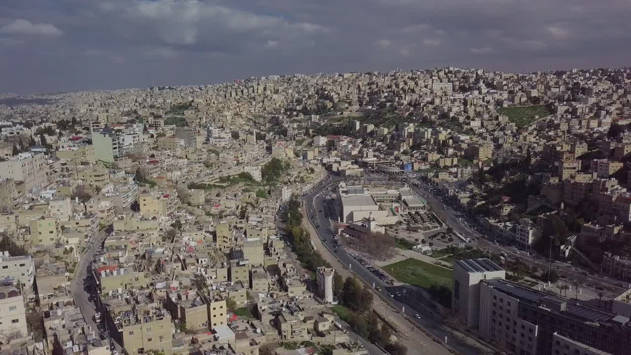 hermoso clip aéreo día nublado de cielos grises sobre amman jordania que muestra la arquitectura y el paisaje de varios niveles de la ciudad, tomado por un dron