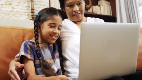 Grandmother-and-granddaughter-using-laptop-in-living-room-4k