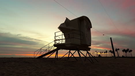 Un-Colorido-Amanecer-Con-Una-Torre-De-Salvavidas-En-Silueta-En-Primer-Plano-En-Cabrillo-Beach,-San-Pedro-California---Lapso-De-Tiempo