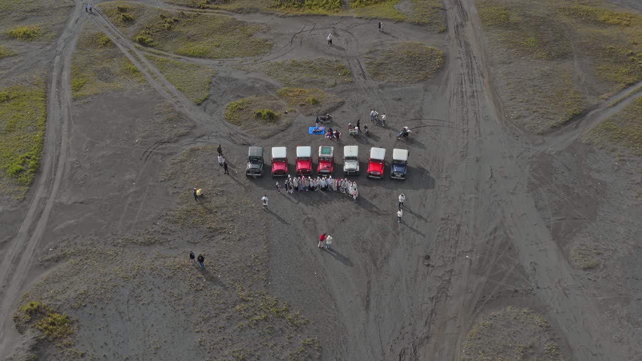 Aerial view of tourists posing with off road jeeps in mount bromo