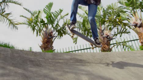 Low-Angle-Ansicht-Eines-Jungen-Kaukasischen-Mannes,-Der-Auf-Der-Rampe-Im-Skateboardpark-Einen-Skateboard-Trick-Macht,-4k