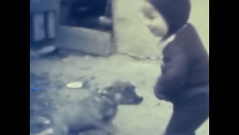 little boy standing next to black dog in soviet union archive. circa ussr 1980s: a heartwarming image of a little boy standing next to a loyal black dog in the soviet union.