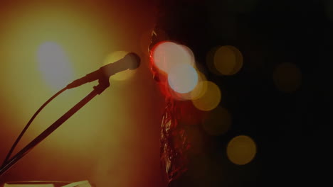 Caucasian-female-singer-singing-and-playing-keyboard-during-concert-over-light-spots