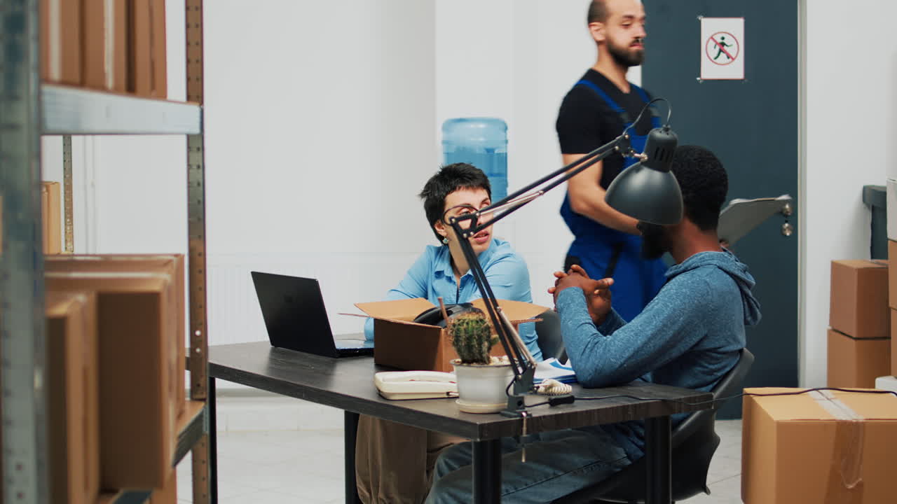 Warehouse team working at desk with boxes and laptop