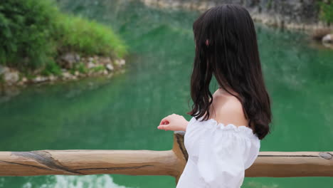 초록색 호수 에서 걸어다니는 소녀가 풍경과 문화 예술적 개념을 바라보고 있습니다.
