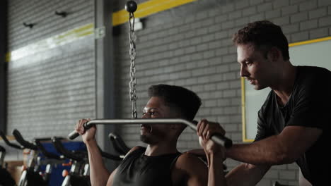 man working out with personal trainer in a gym