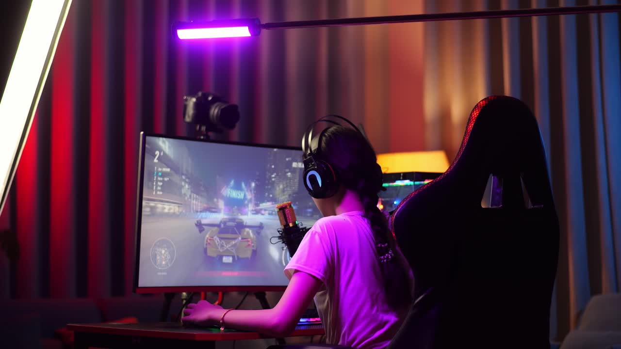 아시안 소녀 스트리머의 뒷면은 실망감을 느끼고 개인 컴퓨터에서 자동차 레이싱 게임을 실패합니다. 라이브 스트리밍 비디오 게임, rgb led 스트립 라이트에 의해 조명 된 책상