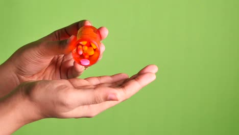 close up de la mano del hombre tomando la medicina en el fondo verde