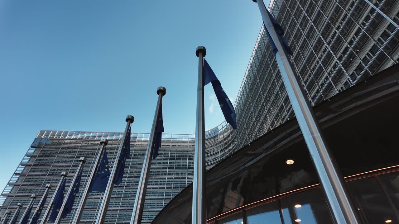 Low-angle shot of EU flags fluttering outside European Commission building