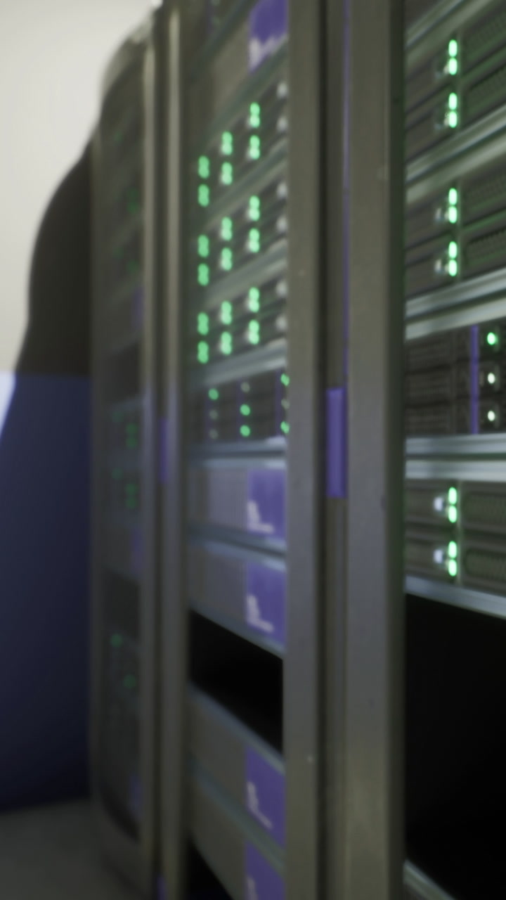 Servers with green lights show activity in a data center in the evening