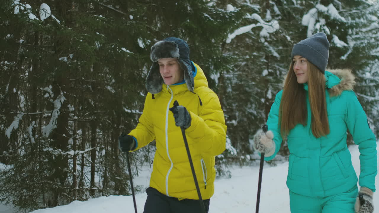 Slow motion shot of a loving couple skiing in the woods on the eve of Valentine's day