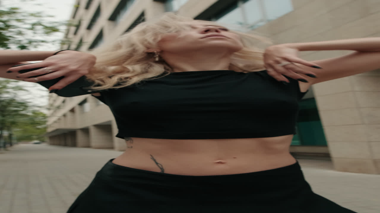 Giovane donna bionda elegante in posa in ambiente urbano