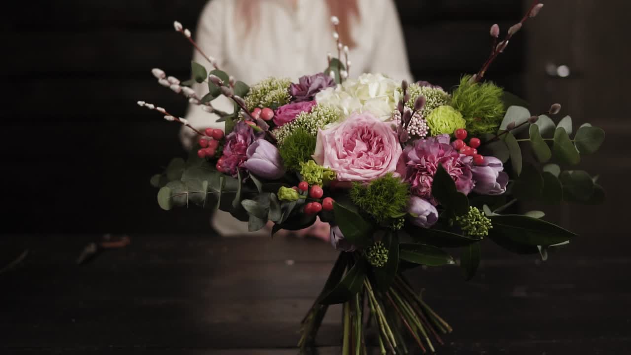 A survey slow-motion footage of an amazing bouquet of flowers arranged by a florist. Blurred background