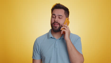 tired sleepy young caucasian man having annoyed boring talk on smartphone with friend conversation