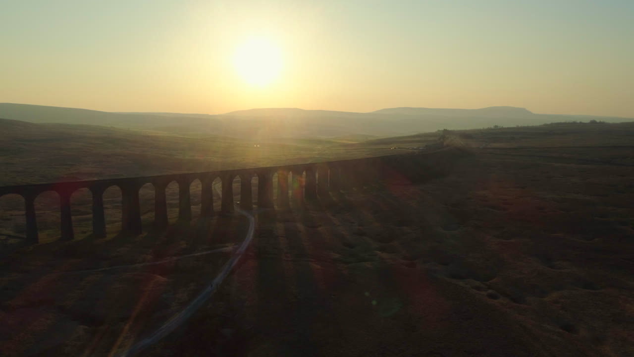 toma aérea de drones del puente de tren del viaducto ribblehead recortado en el impresionante amanecer en verano en los valles de yorkshire inglaterra reino unido con colinas en el fondo