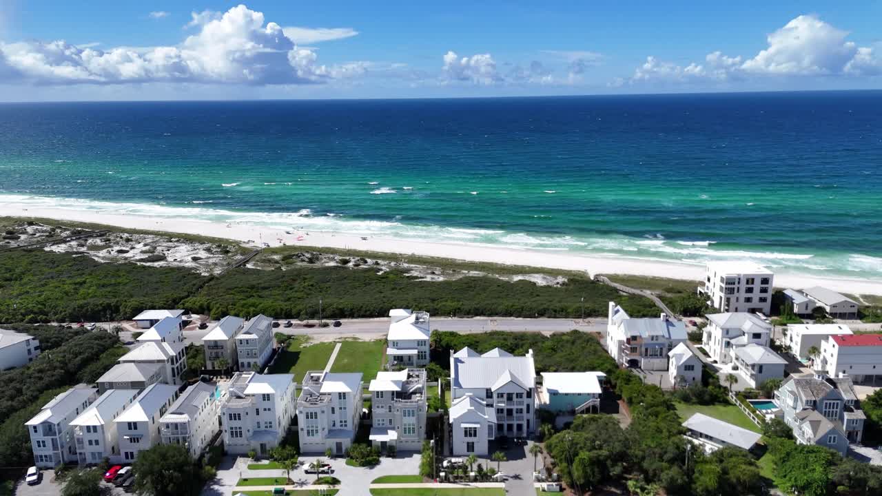 Amazing drone movement over the sunny beachside of the 30A luxury apartments area towards the beautiful turquoise ocean, Florida, USA