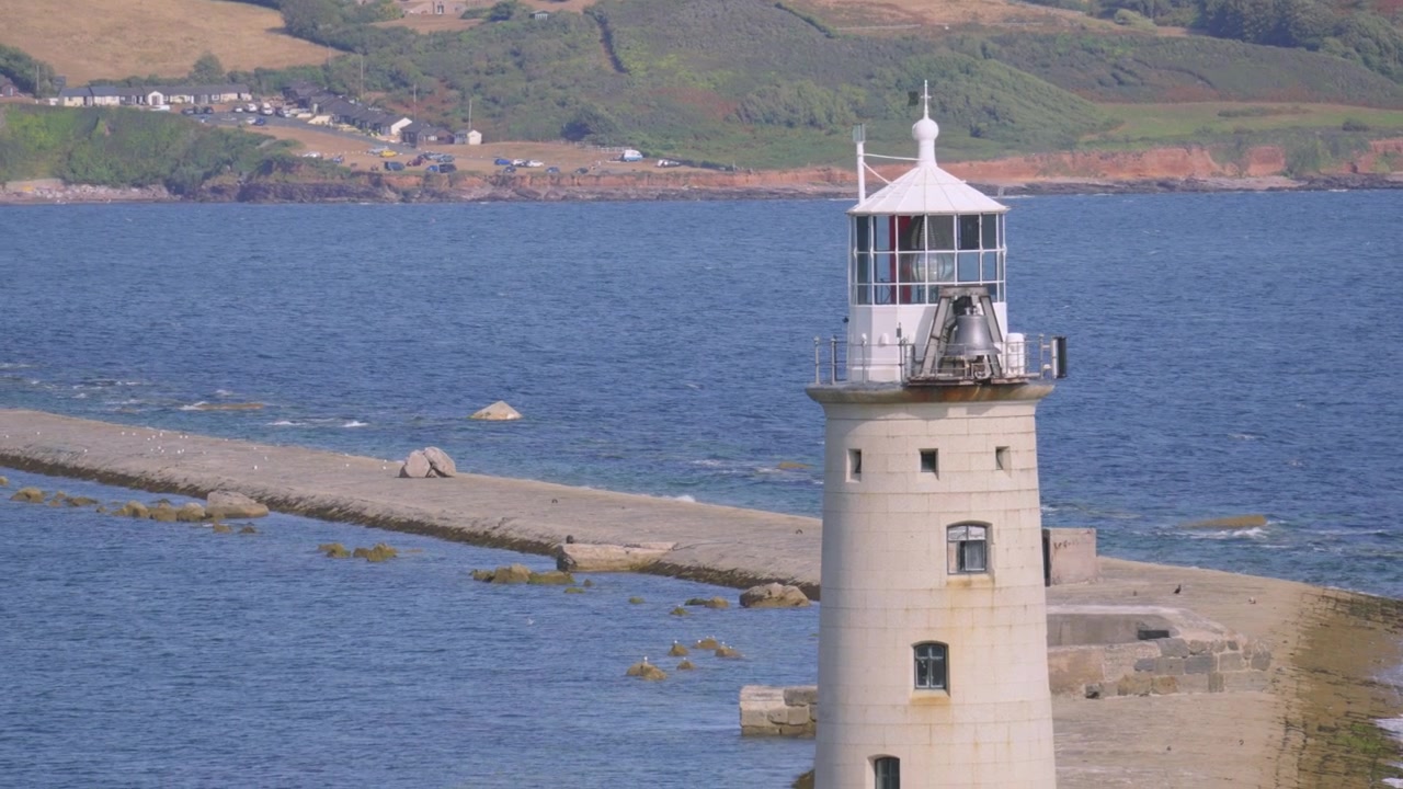 Vista del faro di Plymouth Breakwater con mare calmo. Costa del Devon meridionale
