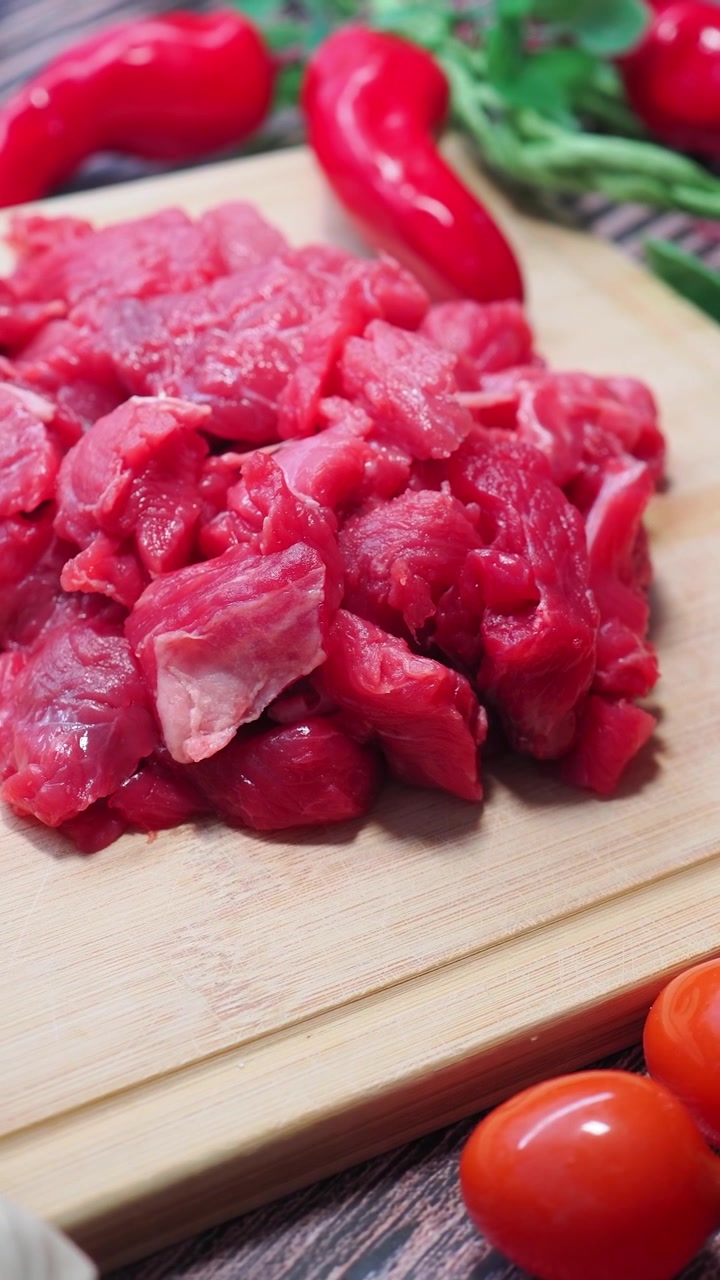 Potongan Daging Sapi Mentah Segar di Atas Talenan Kayu
