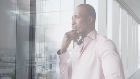 animation of african american businessman in office over people walking and cityscape