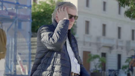 ein tourist sieht sich in der stadt um und richtet seine haare