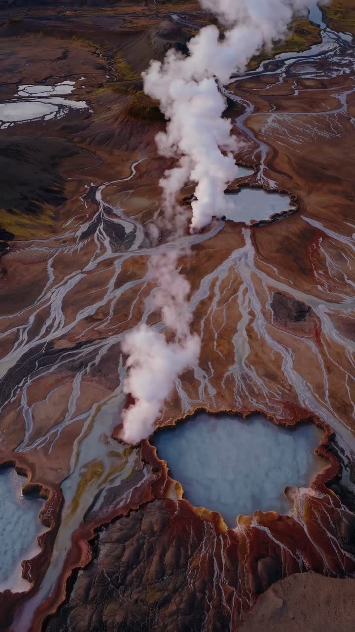 Vista aerea in video di un paesaggio vulcanico con sfiati di vapore, fiumi e montagne in lontananza