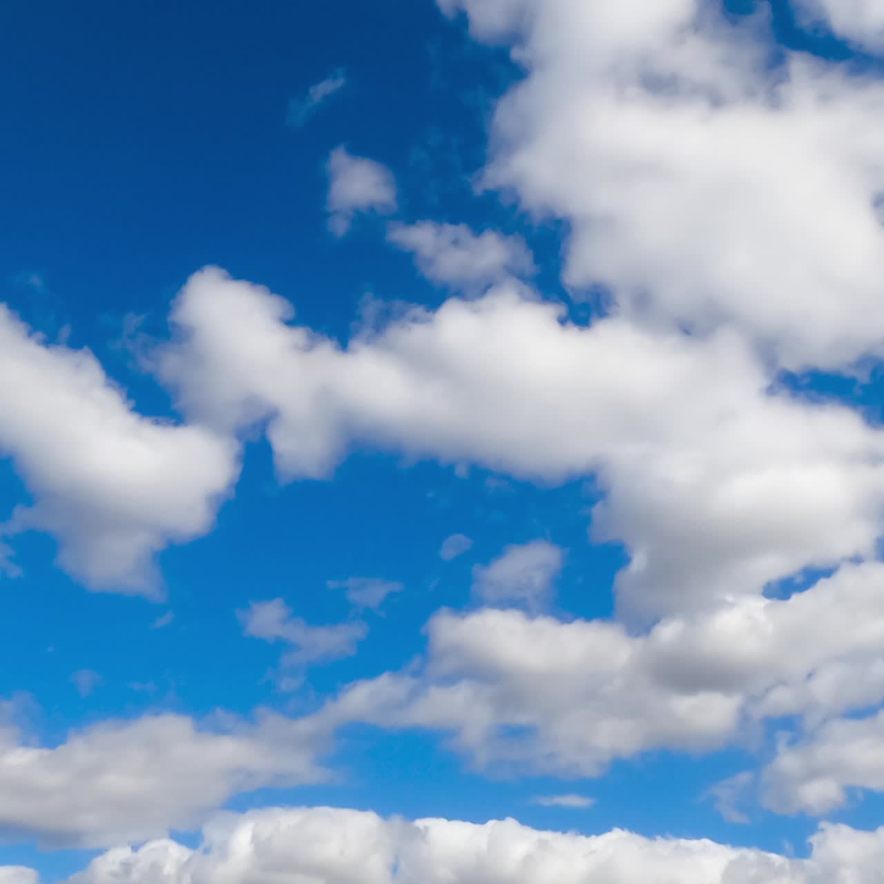 Fluffy soft white clouds moving by the azure skies. Cloudscape formation in the atmosphere. Timelapse