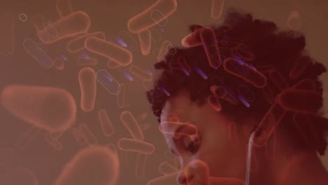 animation of bacteria over african american female doctor checking girl