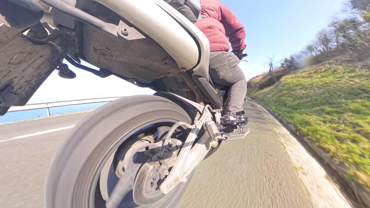 Guidare una Moto su una Strada Soleggiata con Vista sull'Oceano