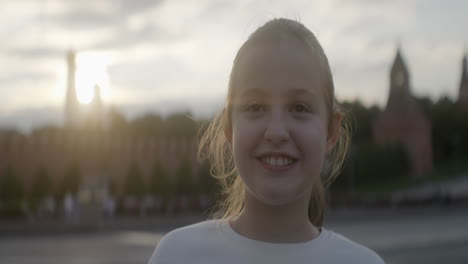 smiling girl in front of the kremlin at sunset