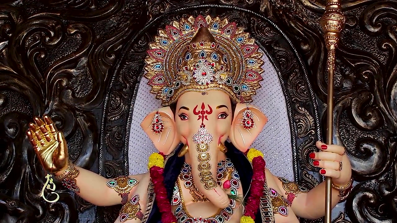 Vista frontale dell'idolo di Ganesha che mostra la corona d'oro, la mano alzata e la mazza durante il festival di Ganesh Chaturthi in India