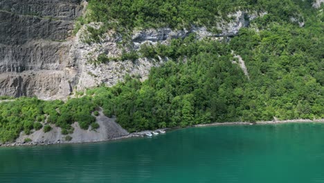 Dreifarbige-Naturschönheit-Aus-Rustikalen-Felsen,-Grüner-Vegetation-Und-Türkisfarbenem-Wasser