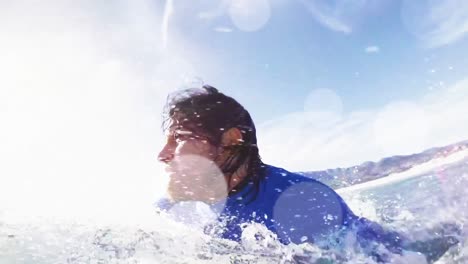 animación de luces y bokeh sobre un feliz surfista caucásico surfando en las olas