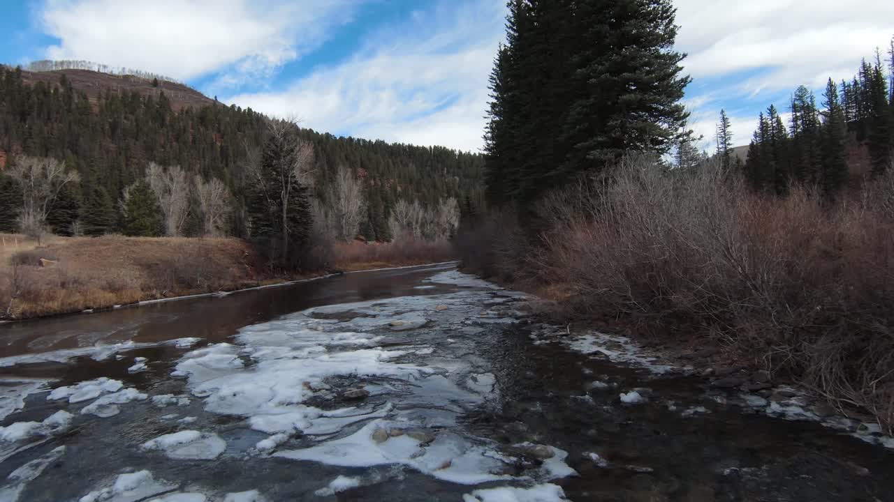 fpv volando bajo sobre el río en las montañas
