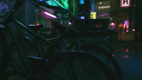 bikes parked in a neon-lit night city street