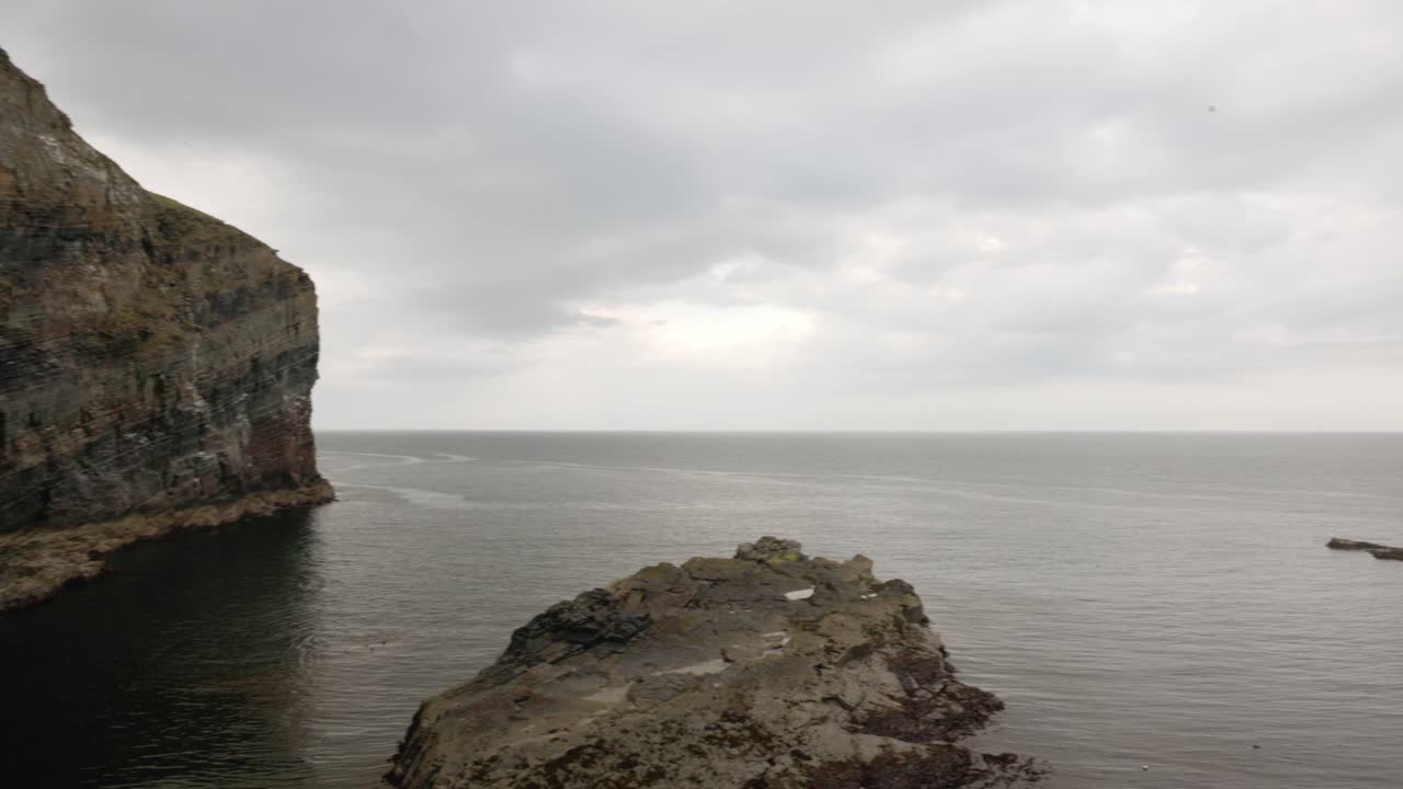 Panning shot of the beautiful scenery at the bottom of the Whaligoe Steps