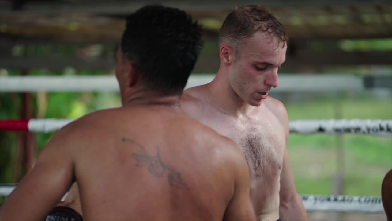 Two shirtless men training in a boxing ring