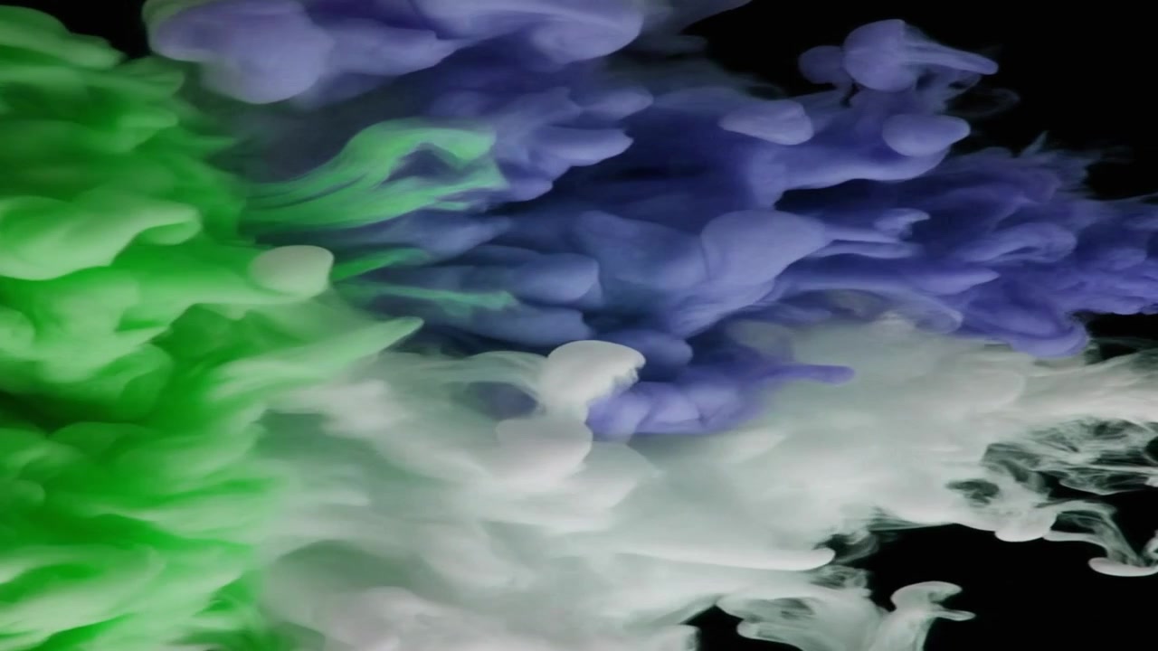 Nuvole di inchiostro verdi, blu e bianche che turbinano nell'acqua