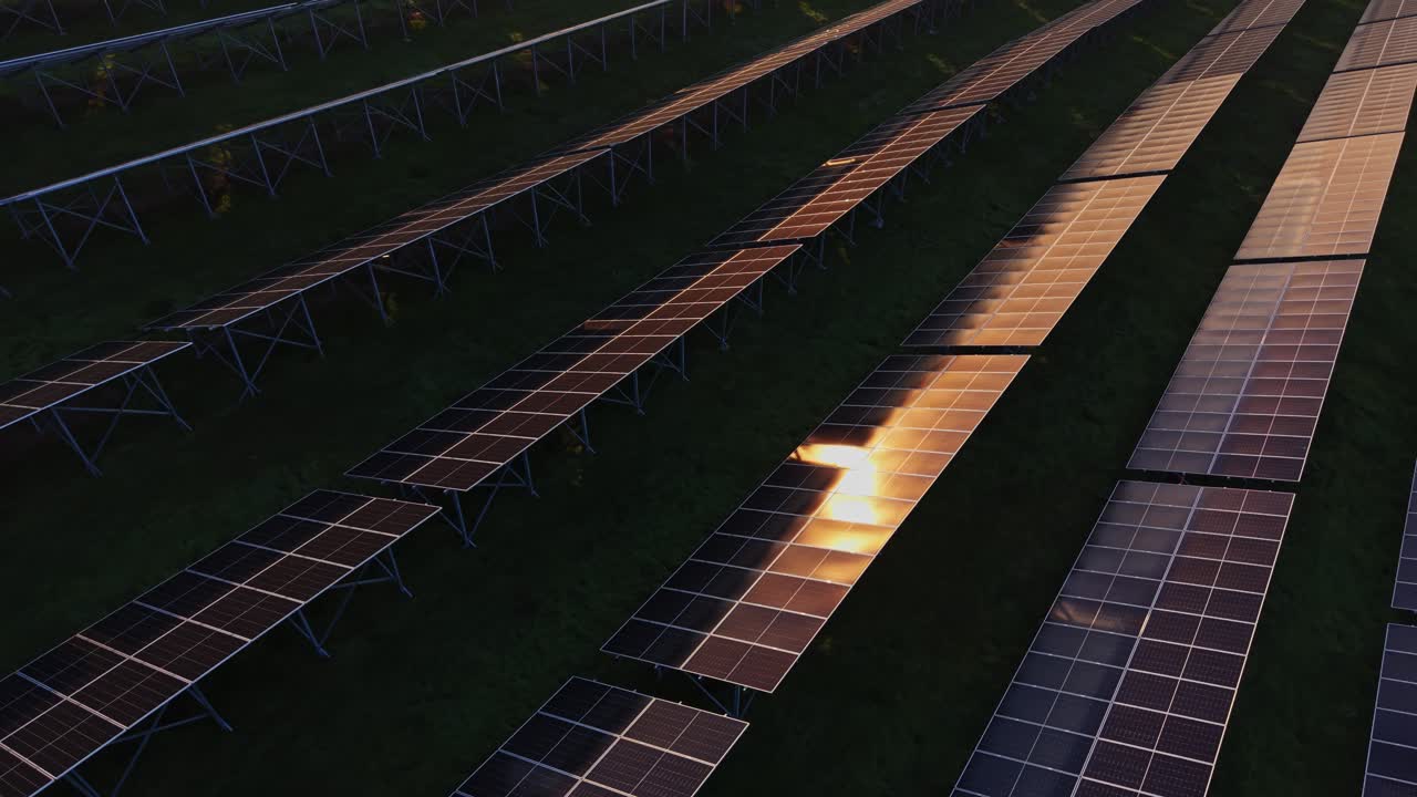 Rows of solar panels generate energy at sunset on a clear day