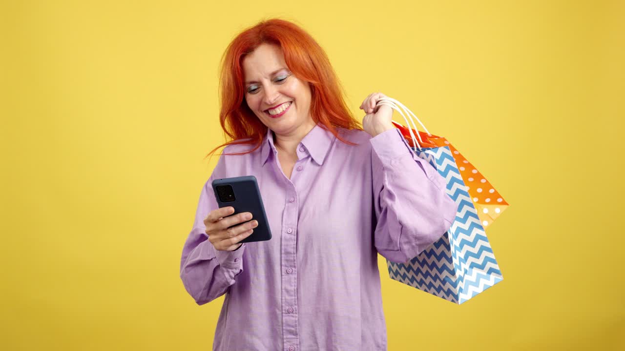 Happy woman with shopping bags using smartphone