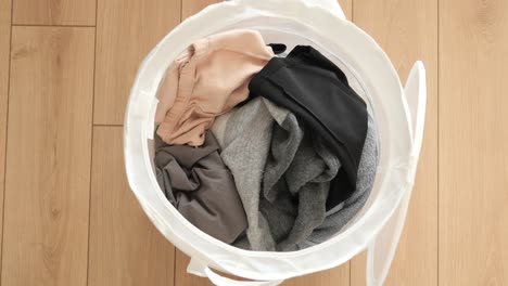 a white laundry basket full of dirty clothes