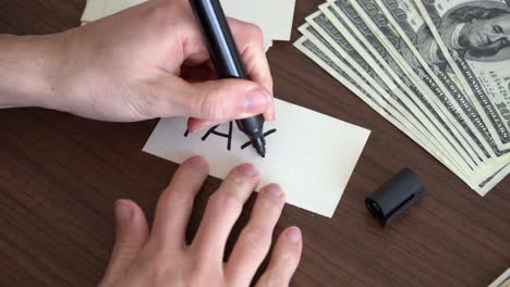 Writing-the-word-"taxes"-on-a-piece-of-paper