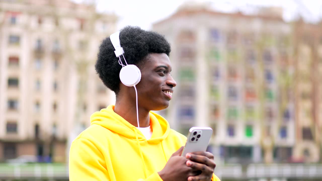 Young man with headphones and smartphone in urban setting