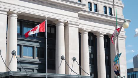 Senate-of-Canada-building-with-Canadian-flags-on-a-sunny-summer-day-in-Ottawa,-Canada---4K-slow-motion