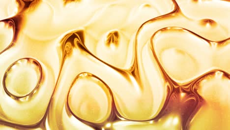 looped abstract background with wavy sparkling golden liquid pattern on shiny glossy surface. viscous blue fluid like surface of gold foil or brilliant glass. beautiful creative festive backdrop.